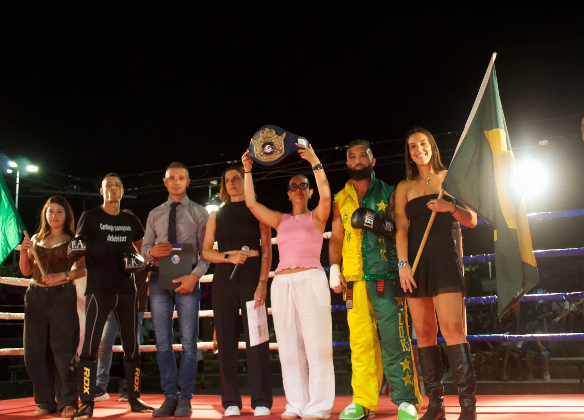 Premiazione IKTA con cintura del titolo, bandiere e staff sul ring